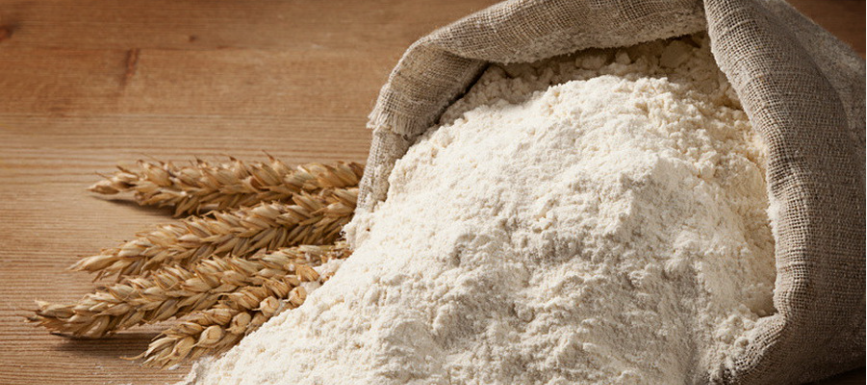 Мешок с рассыпанной мукой и колосья