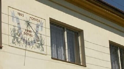 Горизонтальные линии, которые тянутся по фасаду дома, в том числе через солнечные часы, вызваны тенью электрического воздушного провода. Аналогичный негативный эффект могут вызвать и разные другие строения или оборудование вблизи солнечных часов